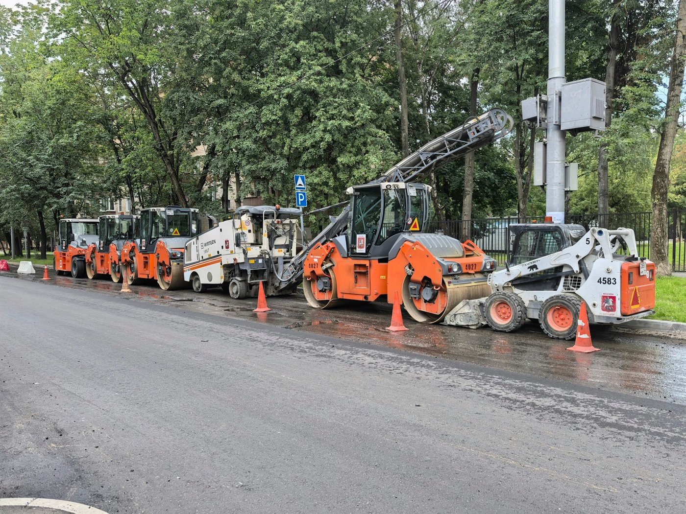 Straßenbaumaschinen am Rand einer frisch bearbeiteten Fahrbahn
